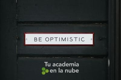 Letrero en una puerta con el mensaje "Be optimistic"